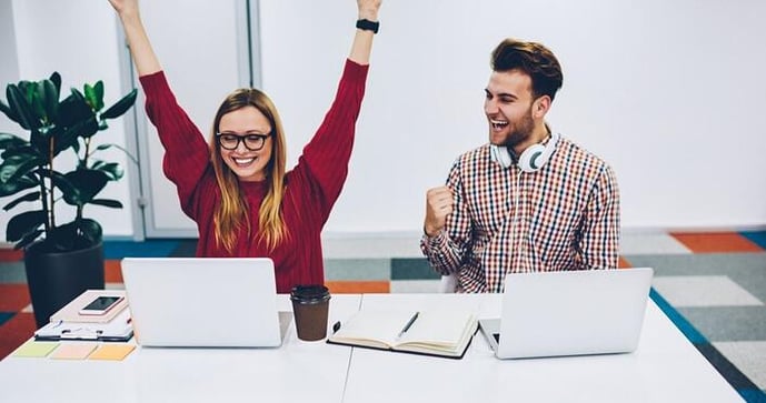 Dos jovenes celebrando y estudiando en su curso de inglés creando un buen ambiente de estudio.