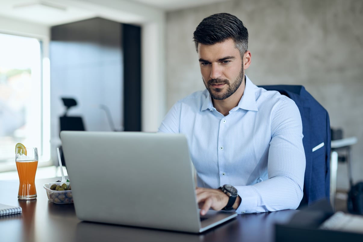 empresario-masculino-que-usa-computadora-mientras-trabaja-oficina