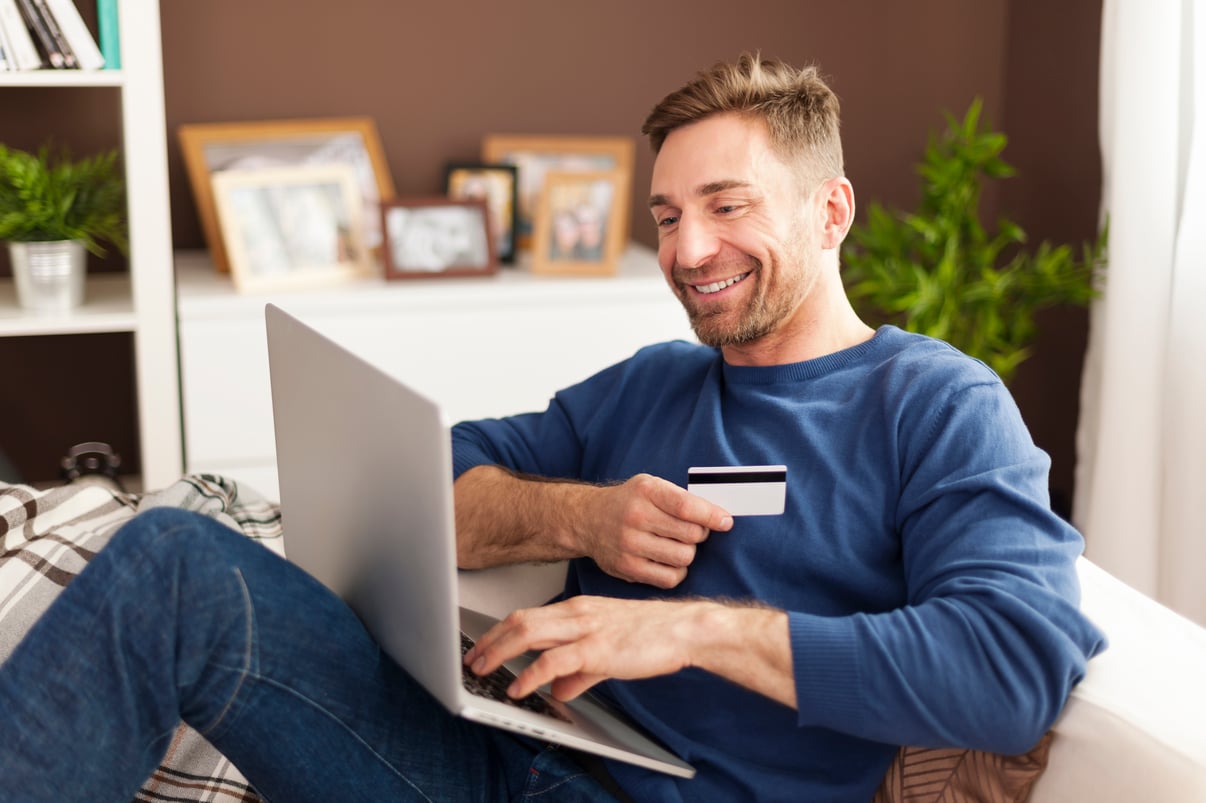 hombre-sonriente-compras-online-casa