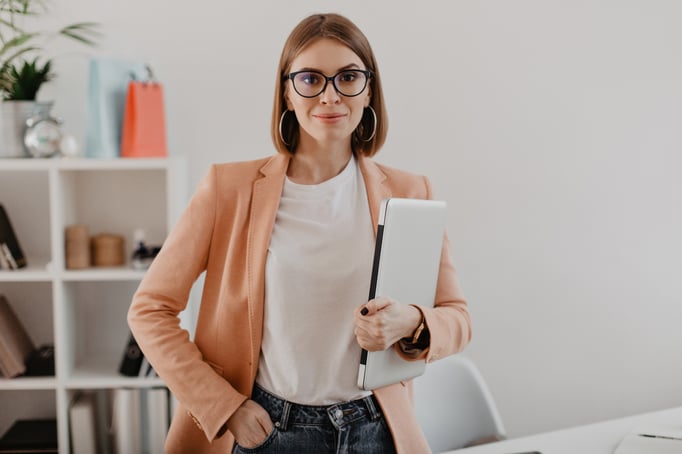 portrait-successful-business-woman-with-glasses-light-jacket-smiling-against-white-office