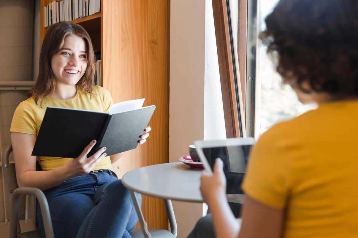 teenager-with-book-talking-with-friend-library