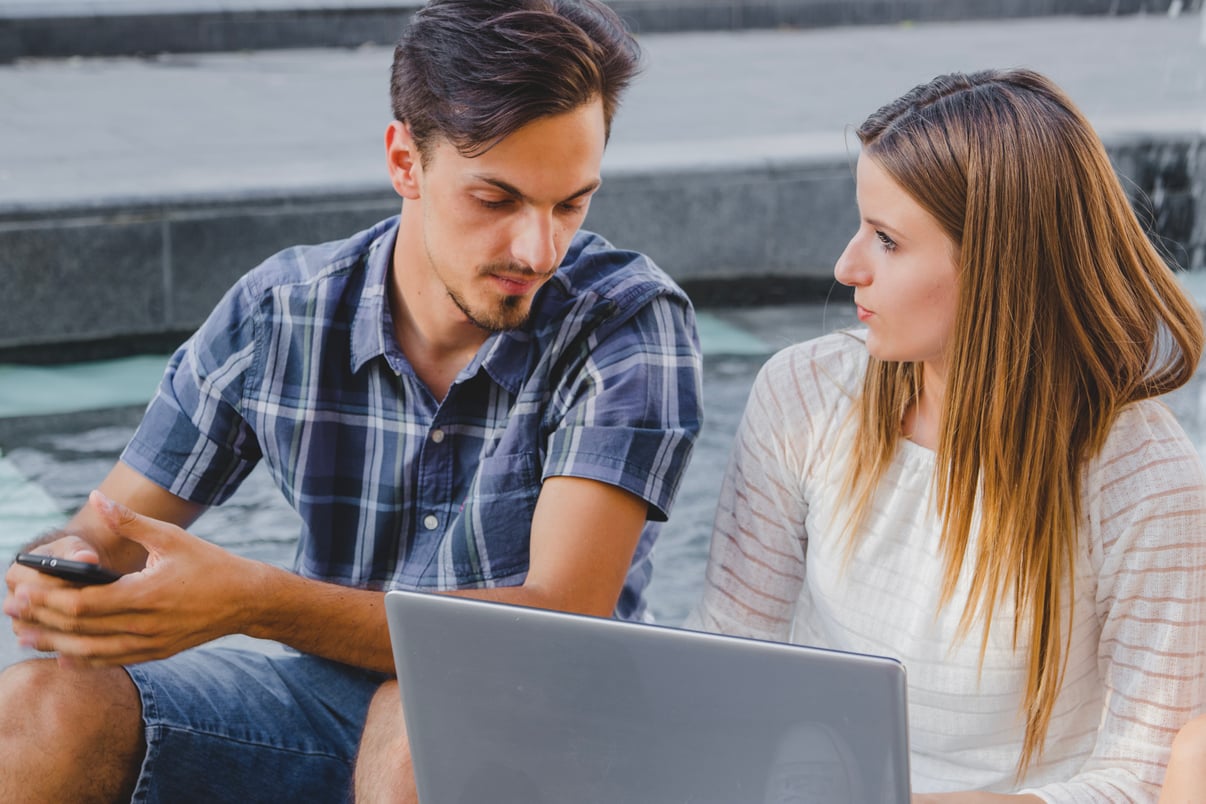 youngsters-talking-while-watching-laptop